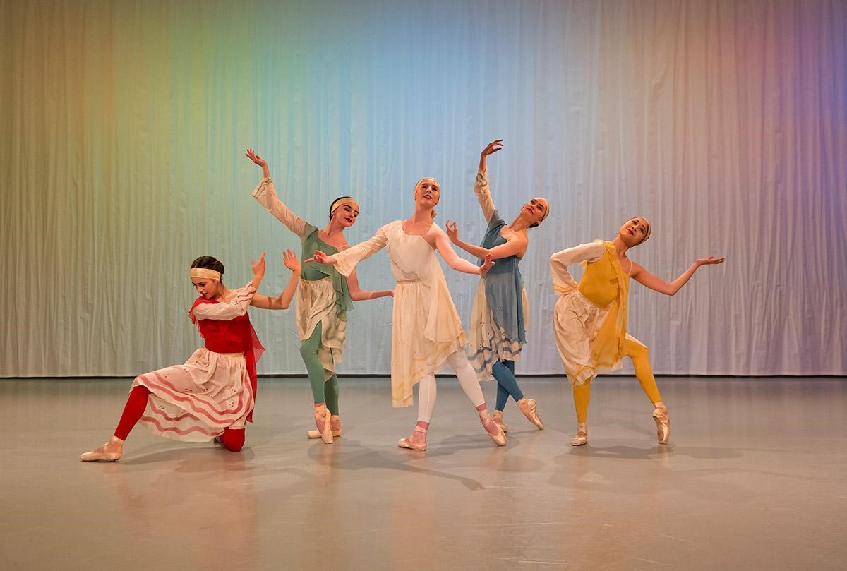 Image of ballet dancers posing in red, green, white, blue and yellow outfits