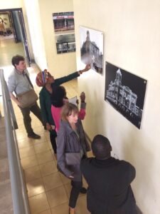 Exhibition visitors looking at two black and white photos, hung on the wall in front of them.