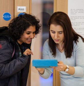 Two people looking at a tablet screen.