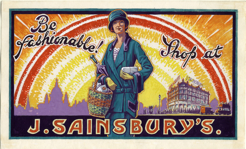 An advert for Sainsbury's that reads 'Be fashionable! Shop at J. Sainsbury's.' A woman is stood front on, wearing a green dress suit and hat, with a wicker basket in the crook of her right arm and a small paper parcel in her left hand. Behind her is a stylised bright yellow, red and orange sun, and a Sainsbury's shop to her left.