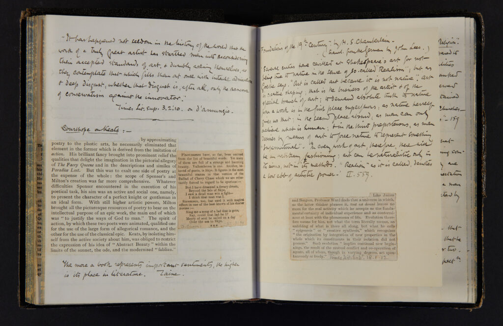 The open page of a handwritten book with clippings of text from other books stuck inside.