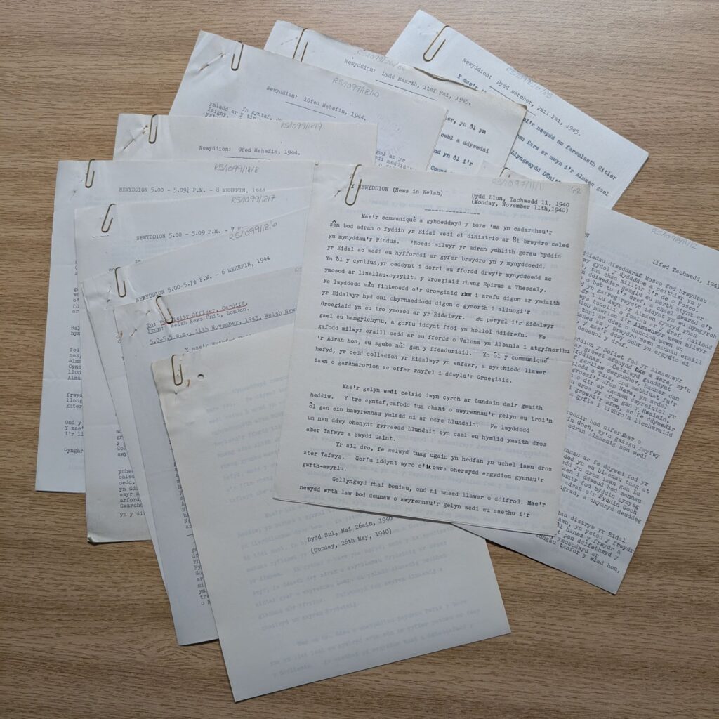 A smattering of paper documents laid out on a wooden surface.