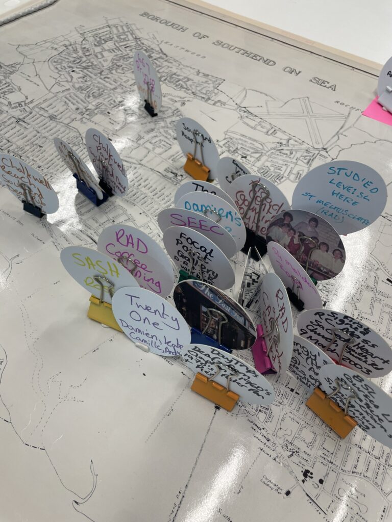 Upright paper markers with annotations written on them standing on a map
