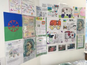 A wall display of drawings, mind maps and illustrated posters about the Roma community
