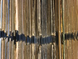A close-up shot of several vinyl record sleeves stacked against one another.