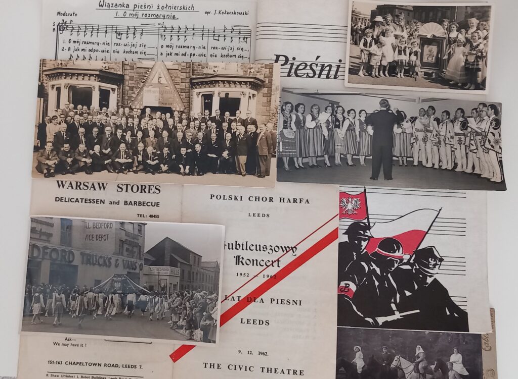 A collection of archive material laid out, including black-and-white photographs and written documents