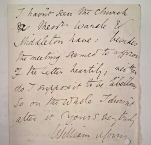 A close-up of a hand written note on a torn piece of paper.