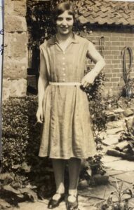 A sepia photograph of a young Florence Julia Street. Florence has a 'bob' hairstyle, and is wearing a sleeveless dress.