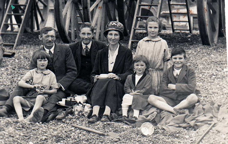 A family, consisting of mother and father and five children, pose on Brighton Beach.