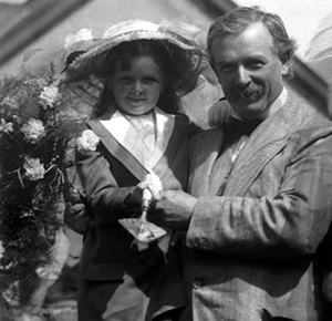 Megan Lloyd George with her father, David. The pair are in the garden, holding a trowel.