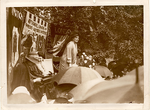 Sepia photo of Eleanor Rathbone speaking at National Union of Societies for Equal Citizenship meeting at Aubrey House, 1925.