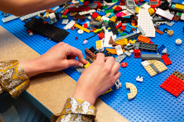 A photograph of hands playing with lego