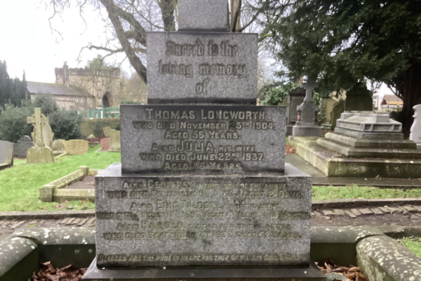A photograph of a grave, the gravestone reads 'In loving memory of Thomas Longworth who died November 5th 1904 aged 55 years. Also Julia, his wife, who died June 22nd, 1937 aged 36 years." 