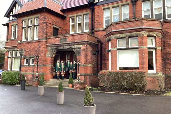 A photograph of Victorian building, Oakhill School, with children pictured on the front step