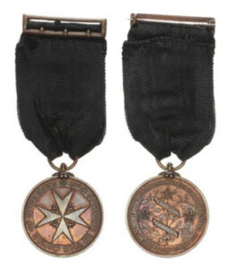 An image of both sides of Miss Pritty's Order of St John medal