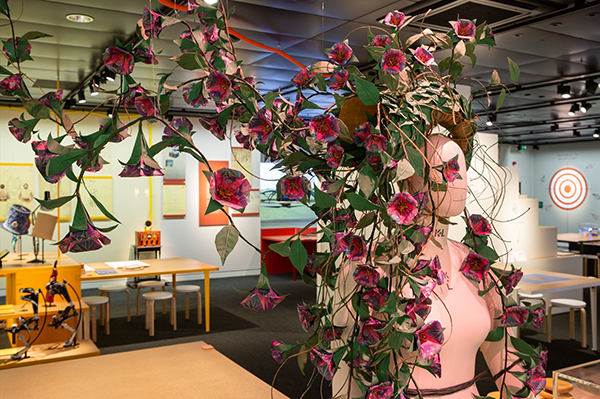 Photograph of origami flower headwear feature in exhibition.
